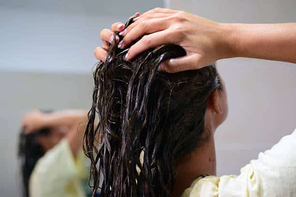 huile amande cheveux femme qui lave ses cheveux